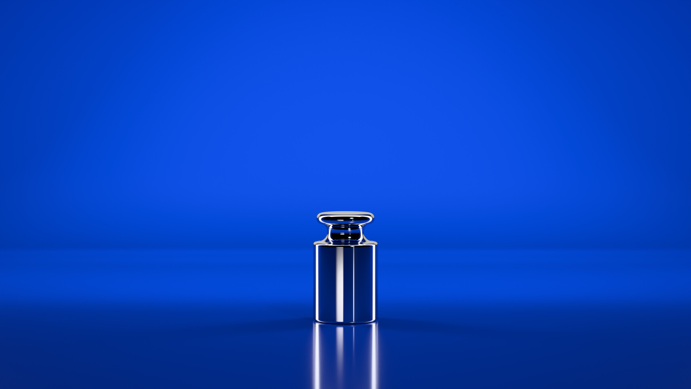 Um peso-padrão de 1 kg, de inox polido, sobre esmalte azul-cobalto.