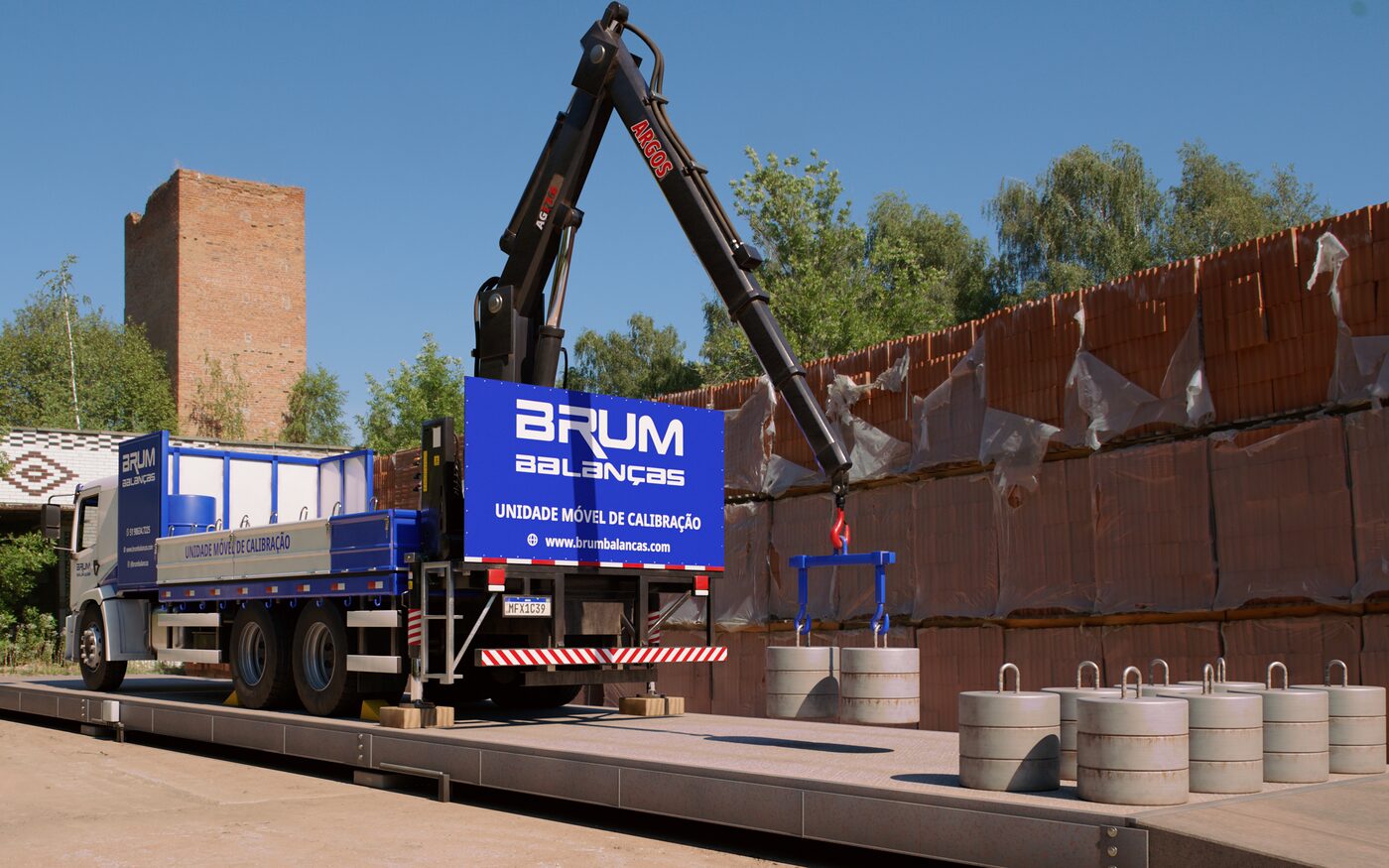 Unidade móvel de calibração da Brum descendo pesos-padrão de 500 kg sobre a plataforma de uma balança rodoviária.